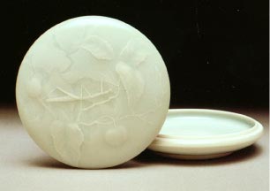 Celadon glazed carved porcelain lidded box, walking stick in wild plum trees